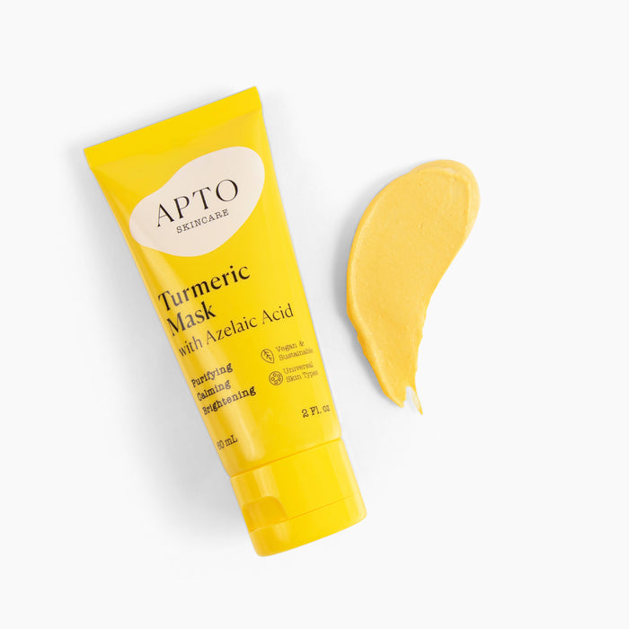 On a white background, a yellow tube of APTO Skincares Turmeric Mask with Azelaic Acid, Soothing & Clarifying Face Mask sits beside a smear of yellow mask cream, highlighting its purifying, soothing, and balancing properties—the ideal cruelty-free skincare option.