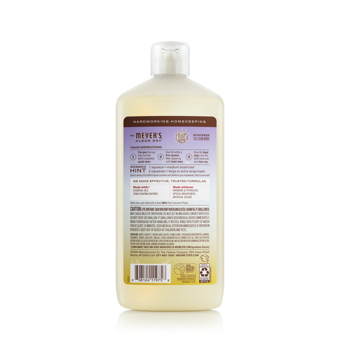 The back of a Mrs. Meyers Ultra Concentrated Liquid Laundry bottle displays a purple label with product details, instructions, and warnings. Partially filled with light-yellow liquid, this laundry soap offers a garden-inspired scent to enhance your cleaning routine.