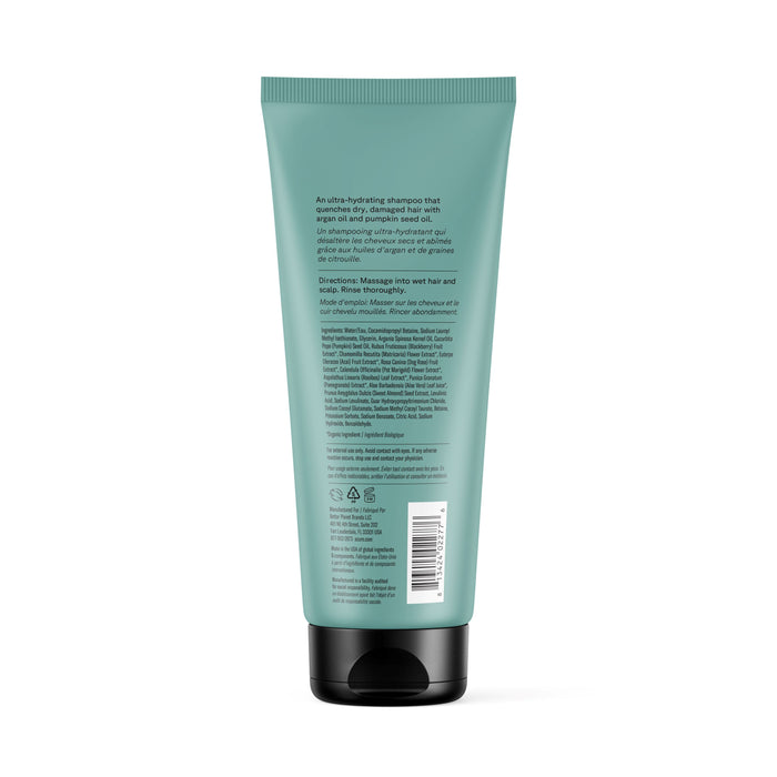 A green Acure Ultra Hydrating Shampoo tube with a black flip cap is shown from the back. The label describes shampoo for curly hair, listing product info, directions, and ingredients in small black text. Brand name is not visible.