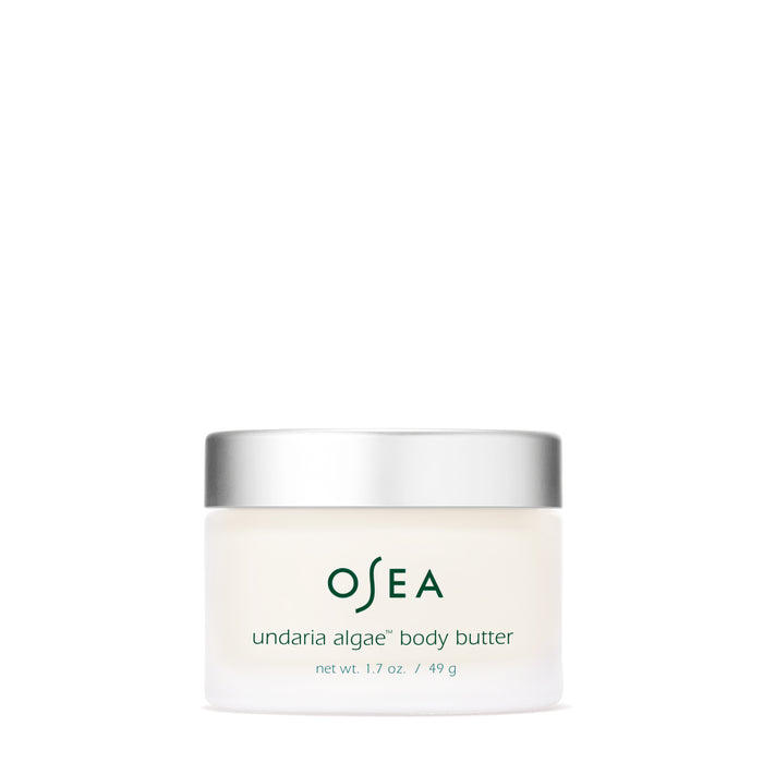 A small, minimalistic white jar with a silver lid is labeled OSEA Undaria Algae™ Body Butter. It contains 1.7 oz (49 g) of moisturizing product, featuring green text on a translucent background.