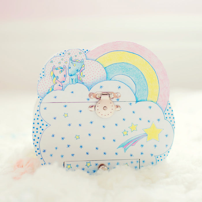 The DJECO Unicorn Dreams Musical Treasure Box is a colorful, cloud-shaped storage solution adorned with a rainbow, two cartoon animals, and star patterns. It includes a metal latch and lock on a soft white surface, blending function and whimsy for toy enthusiasts.