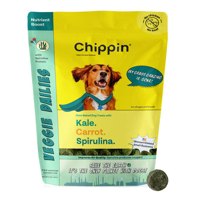 A colorful Chippin package of Veggie Dailies with Spirulina dog treats features a smiling dog, vegan ingredients like kale, carrot, and spirulina, a No Chicken? No Beef? sustainable nutrition label, and a round treat beside the bag.
