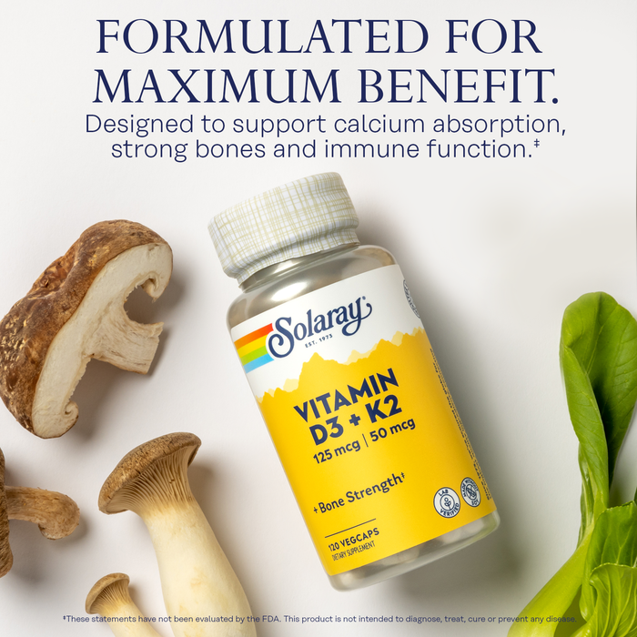 A bottle of Solaray Vitamin D3 + K2 sits on a surface with mushrooms and leafy greens. Text above reads: "Formulated for Maximum Benefit. Designed to support calcium absorption, strong bones and immune function.
