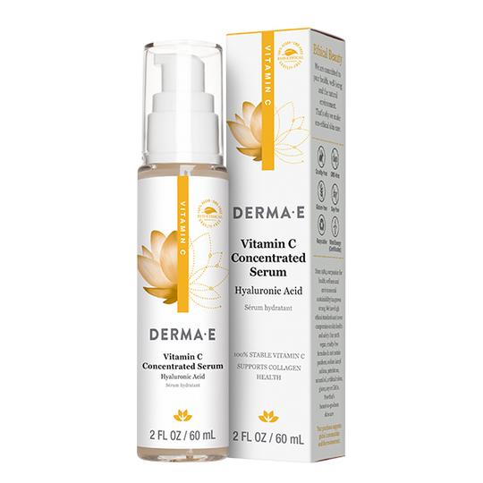 The Derma E Vitamin C Concentrated Serum with Hyaluronic Acid features a golden lotus design on the bottle, displayed alongside its box. The white pump dispenser highlights Stay C-50® benefits for enhanced collagen support and hydration.