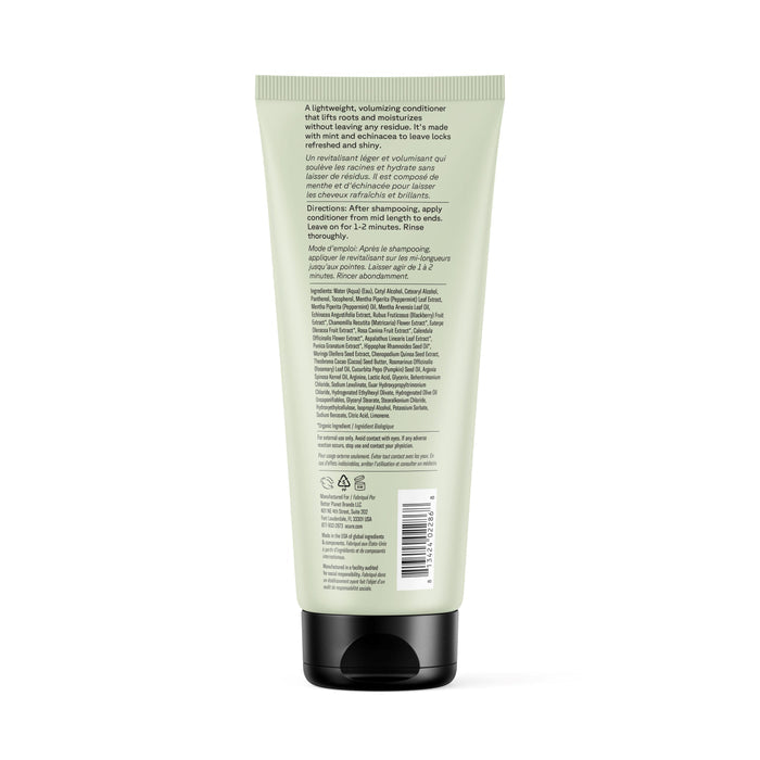 A light green Acure Vivacious Volume Conditioner bottle is shown from the back, highlighting product details, directions, natural hair care ingredients, a barcode, and a black flip-top cap.