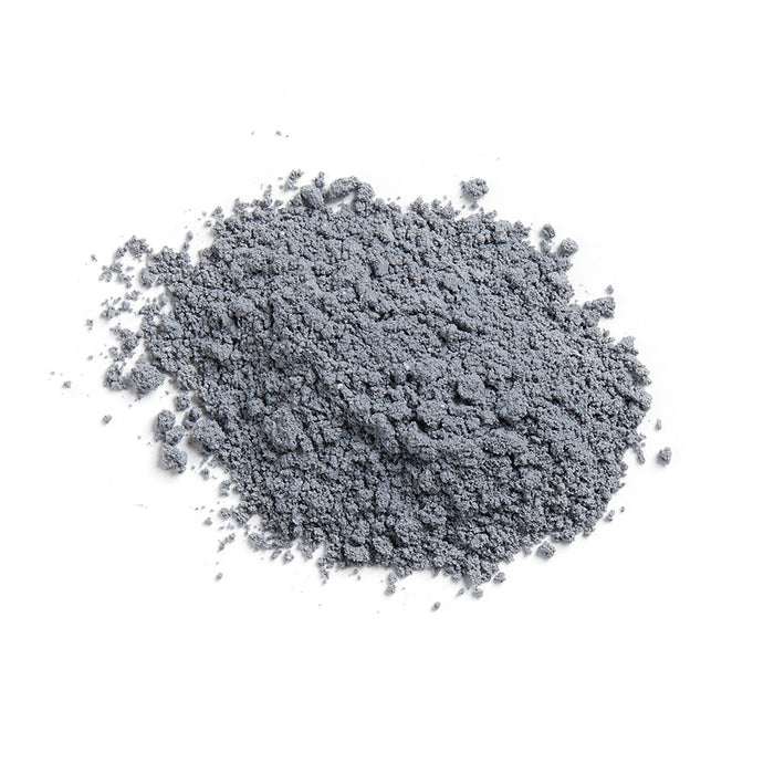 The Volcanic Ash Dry Facial Clay Mask by Terra Beauty Bars, a fine grey vegan blend on a white background, looks like volcanic ash and is perfect for deep cleansing in your facial routine.