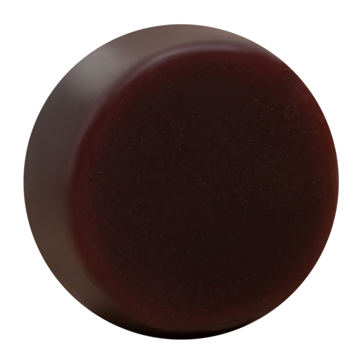The Good Juju Body & Home Volumizing Conditioner Bar for Oily/Fine Hair is a round, smooth, dark brown solid—perfect for natural hair care and sits elegantly against a white background.