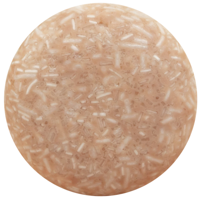 The Good Juju Body & Home Volumizing Shampoo Bar for oily and fine hair is a round, light brown bar with white and beige textured flecks, shown on a white background.