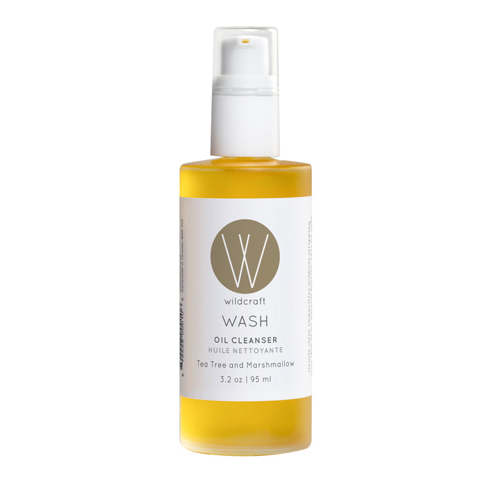 The Wildcraft Wash Oil Cleanser is a 3.2 oz (95 ml) clear bottle with a white pump, featuring tea tree and marshmallow in botanical oils. Its minimalistic design includes the brand logo and product description.