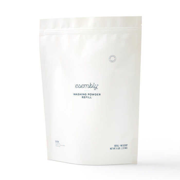 Esembly Babys Washing Powder Refill Bag is an all-natural detergent in a sleek white resealable package with small blue text and logo. This eco-friendly bag stands upright on a plain white background, ideal for cleaning cloth diapers.