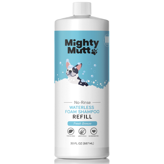 A 30 fl oz white Mighty Mutt bottle labeled Waterless Foam Pet Shampoo Refill features a cartoon dog in a bubble bath, highlighting its hypoallergenic, toxin-free, anti-itch, and deodorizing formula.