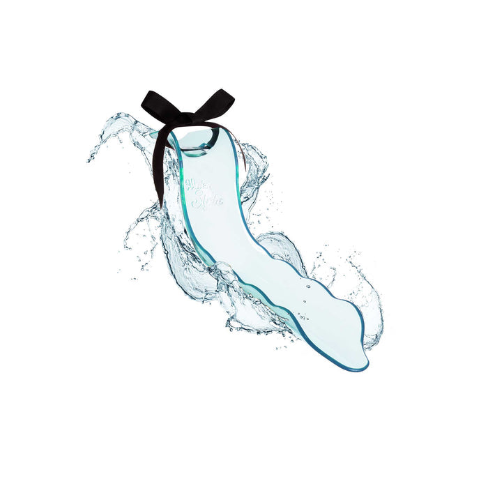 A blue, wavy glass bottle adorned with a black neck ribbon floats amid water splashes, reflecting WaterSlydes elegance from Lovability. Its surface features stylish cursive writing, emphasizing the aquatic stimulators sensory delight.