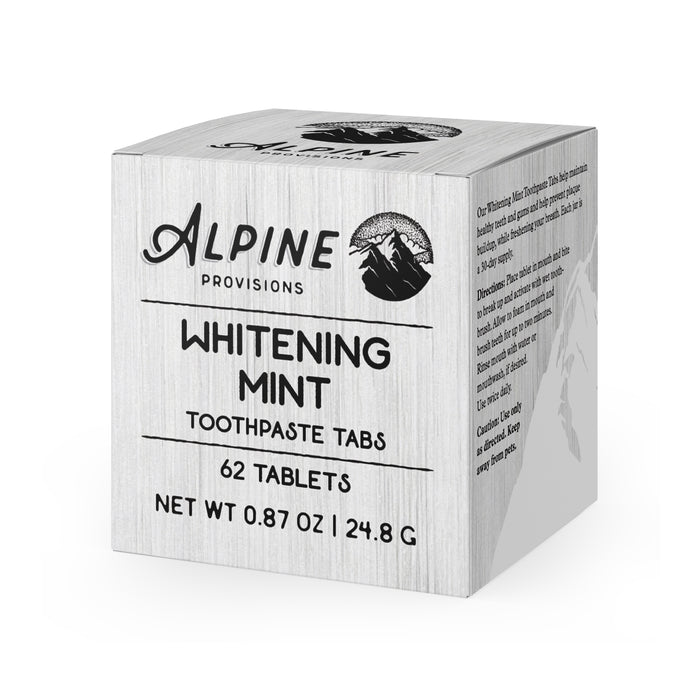 The square box of Alpine Provisions Whitening Mint Toothpaste Tabs features mountain graphics and contains 62 tablets, weighing 0.87 oz (24.8 g). It supports healthy teeth and gums while preventing plaque, with product details on the side.