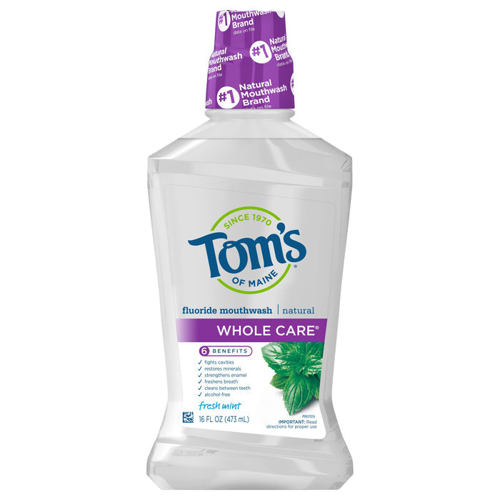 The image shows a 16 fl oz (473 mL) bottle of Toms of Maine Whole Care Anticavity Mouthwash with 6 benefits and a fresh mint flavor, featuring a green mint leaf on the label. Alcohol-free, it is touted as a top natural mouthwash brand.