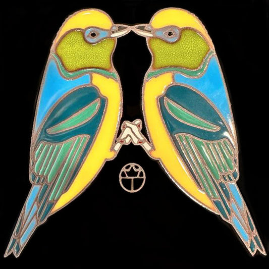 A hand-glazed, hand-fired ceramic tile featuring two colorful lovebirds kissing, with a cork backing.