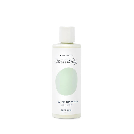 The Esembly Baby foamer bottle in white with a green label and white cap features the brand name and product description Wipe-Up Wash Refill. Its an organic foaming wipes cleanser clearly labeled as 8 fl oz or 236 mL.