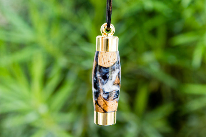Swirled orange blue acrylic keepsake pendant with gold caps on a black cord