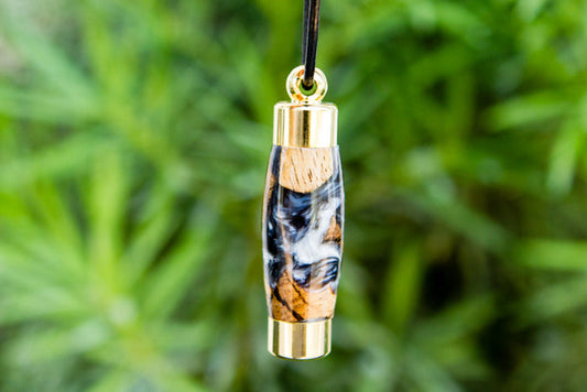 Swirled orange blue acrylic keepsake pendant with gold caps on a black cord