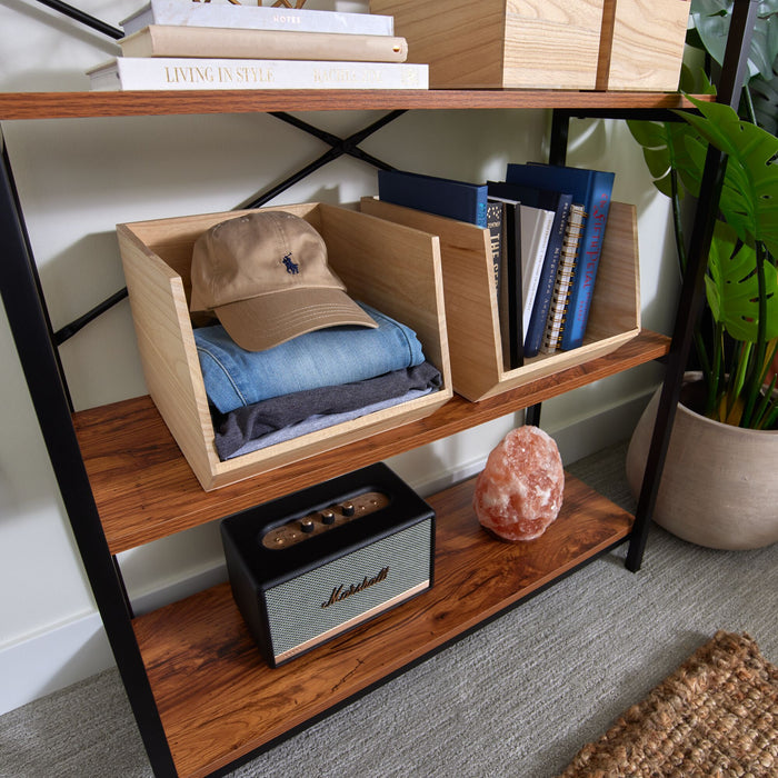 A wooden shelf made from renewable Paulownia wood holds books, a folded pair of jeans, a beige baseball cap, and a small stereo. Nearby, a glowing Himalayan salt lamp enhances the space organized by iDesigns Wood Open Front Bin and is accented by a potted plant.