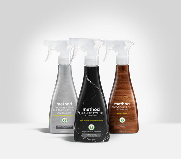 Three Method cleaning products, all with white spray nozzles, are shown on a white background: Stainless Steel Cleaner in silver, Granite Polish in black, and Wood Polish for a natural shine in brown—all are sustainable options.