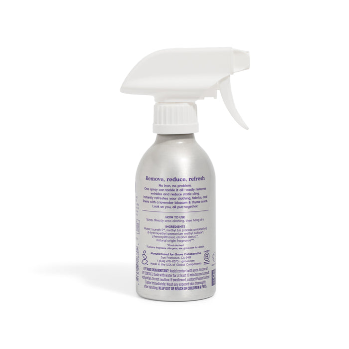 A Grove Co. Wrinkle Release Starter Kit stands upright against a white background, featuring a silver bottle with a white trigger nozzle and purple text describing its use and ingredients; includes a reusable sprayer attachment.